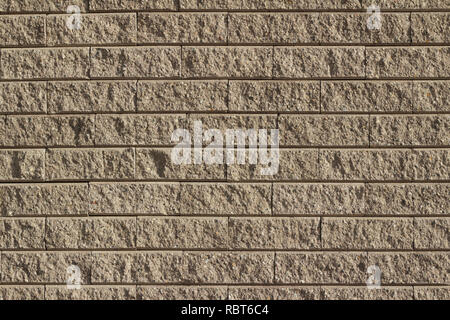 Light brown tan colored rough textured stone brick wall abstract background Stock Photo