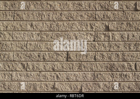 Light brown tan colored rough textured stone brick wall abstract background Stock Photo