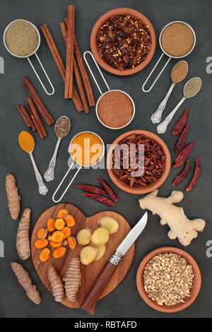 Spices for weight loss with turmeric, cumin, ginger, chilli, cinnamon and gymnema sylvestre used to suppress appetite. Top view on slate background. Stock Photo