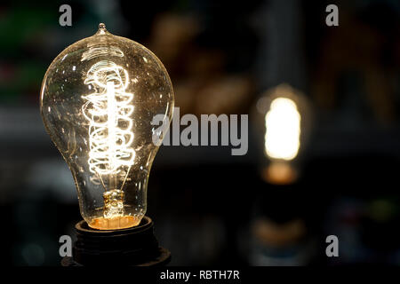 old light bulb glowing in dark . Close up Stock Photo