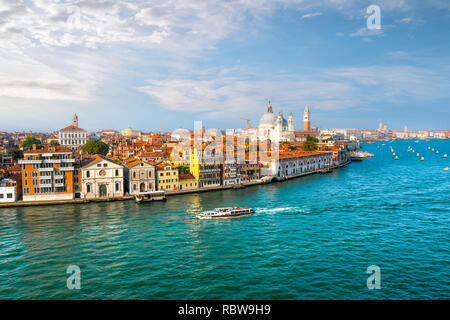 A Venice, Italy water taxi cruises the grand canal with the dome of Santa Maria Della Salute Cathedral, the Campanile and St. Mark's square in view Stock Photo