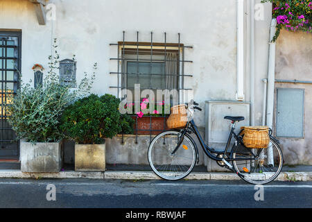 Bicycle with wicker baskets on the street in Orbetello on peninsula in Argentario in Tuscany. Italy Stock Photo