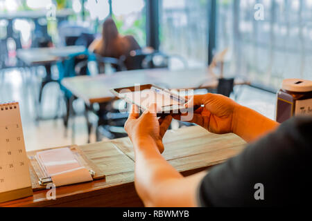 Male waiter giving bills to customer in coffee shop. Stock Photo