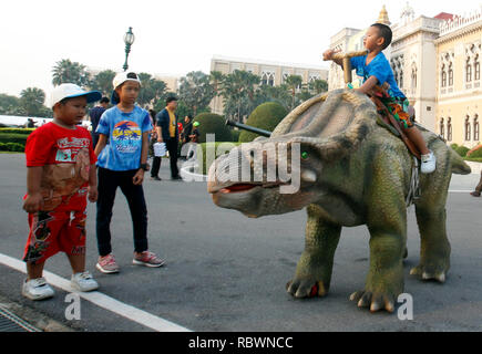 Bangkok, Thailand. 12th Jan, 2019. Children and parent stand next to a dinosaur statue during the Children's Day celebration at Government House in Bangkok, Thailand, on January 14, 2017. Credit: Chaiwat Subprasom/Pacific Press/Alamy Live News Stock Photo