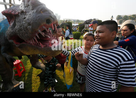 Bangkok, Thailand. 12th Jan, 2019. Children and parent stand next to a dinosaur statue during the Children's Day celebration at Government House in Bangkok, Thailand, on January 14, 2017. Credit: Chaiwat Subprasom/Pacific Press/Alamy Live News Stock Photo