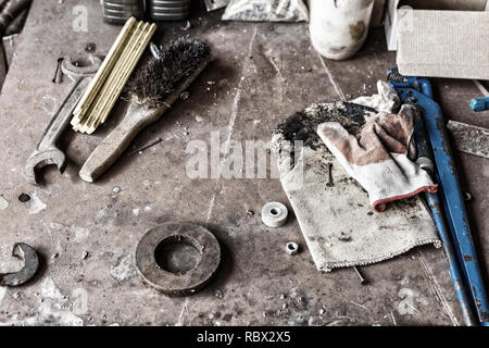 uncleared workshop with tools. on the dirty stone table scattered tools Stock Photo