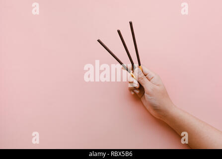 Chocolate stick in female hand on colorful background.food concept idea Stock Photo