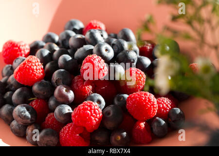 Close up of a large bowl of fresh raspberries and blueberries in a domestic kitchen Stock Photo