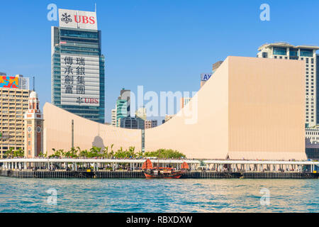Hong Kong Cultural Centre, and clocktower overlook the Kowloon public pier and moored Dukling junk boat, Tsim Sha Tsui, Kowloon, Hong Kong Stock Photo