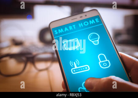 Smart home technology interface on Smartphone app screen, person holding device Stock Photo