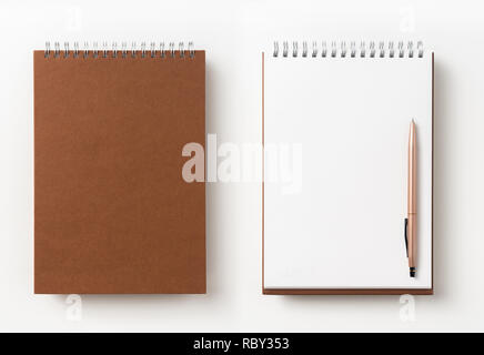Design concept - Top view of brown spiral notebook, white page and pencil isolated on background for mockup Stock Photo