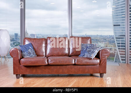 brown armchair against the backdrop of a huge window view from the panoramic windows. Stock Photo
