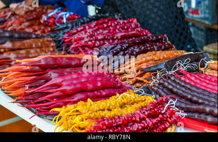 Churchkhela for sale on street market in Mtskheta, Georgia. Traditional Georgian homemade sweets with hazelnuts, honey, wheat flour. Stock Photo