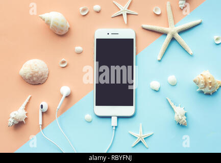 Top view of smartphone and seashell  on color background. Summer, travel concept ideas Stock Photo
