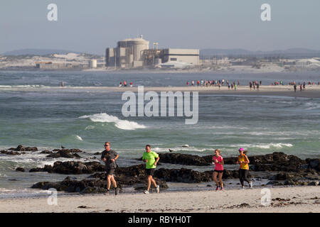 Parkrun jog on the beach at Melkbosstrand with Koeberg Power Station in the background. Parkrun is a global movement of Saturday 5km runs outside.