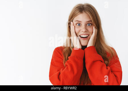 Happy amazed and surprised girl cannot believe what she looking at open mouth in amazement smiling broadly pressing palms to cheeks astonished reacting to positive changes after skincare procedure Stock Photo