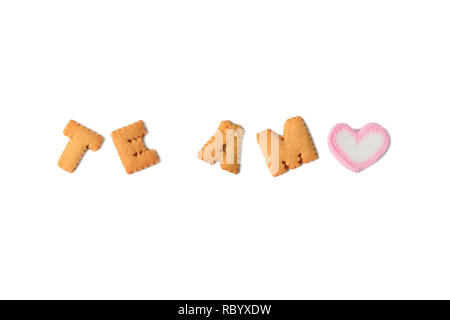 The word TE AMO Meaning I LOVE YOU in Spanish spelled with alphabet shaped biscuits and a heart shaped marshmallow candy on white background Stock Photo