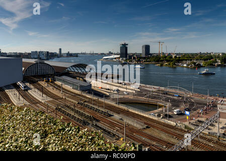 A view of the north Amsterdam skyline, across the main railway tracks and canal. The day is sunny. Stock Photo