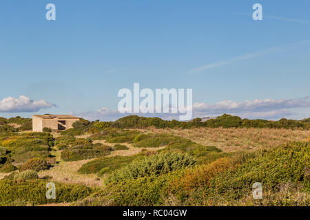 Old sheep barn between mastic bushes, at the coast of Sardinia in Italy Stock Photo