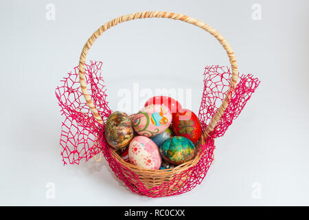 Colorful decorated and painted Easter eggs in wooden basket isolated on white background. Easter holiday concept. Stock Photo