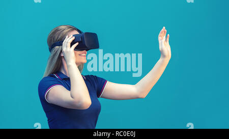 Happy young woman playing on VR glasses indoor – Virtual reality concept with young girl having fun with headset goggles touching air during VR experi Stock Photo