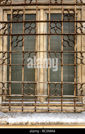 An old window with broken paint and decorative bars. Close-up photo. Stock Photo