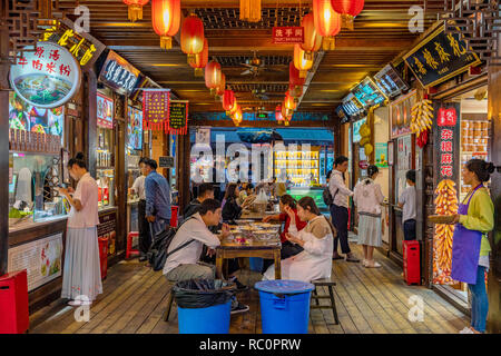 CHENGDU, CHINA - SEPTEMBER 25: Traditional street food vendors selling local Sichuan food at Jinli Ancient Street night market on September 25, 2018 i Stock Photo