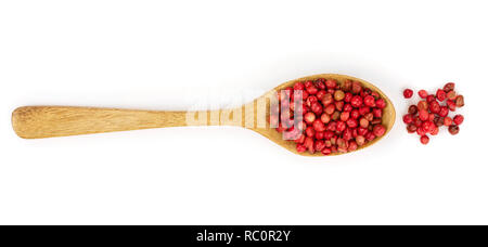 red peppercorns seeds in wooden spoon isolated on white background. Top view. Flat lay. Stock Photo