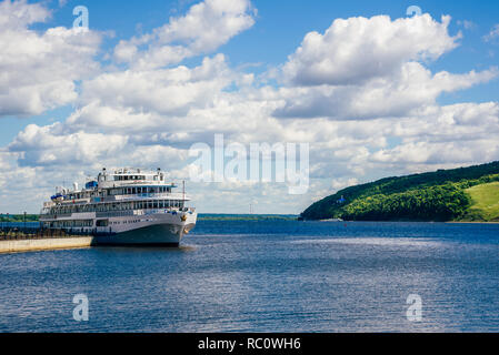 White Cruise Ship at the Pier. Coast with Forest and Temple on Background. Stock Photo