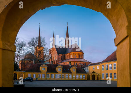 Roskilde cathedral in the soft sunset under the yellow portal of Roskilde Palace, January 11, 2018, Roskilde, Denmark Stock Photo