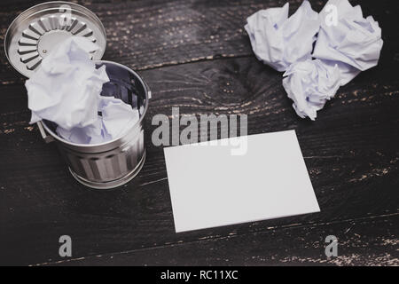 garbage bin on desk setting with pencil notepad and scrunched paper balls, concept of drafting and struggling to write documents Stock Photo