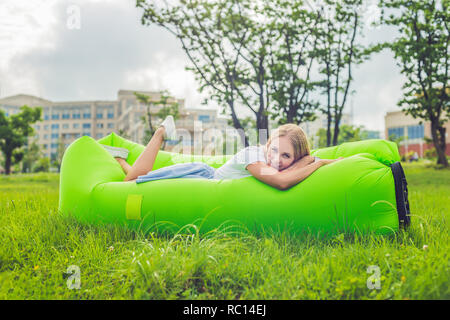 Young woman resting on an air sofa in the park. Stock Photo