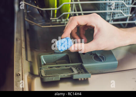 Dishwasher with dirty dishes. Powder, dishwashing tablet and rinse aid. Washing dishes in the kitchen Stock Photo