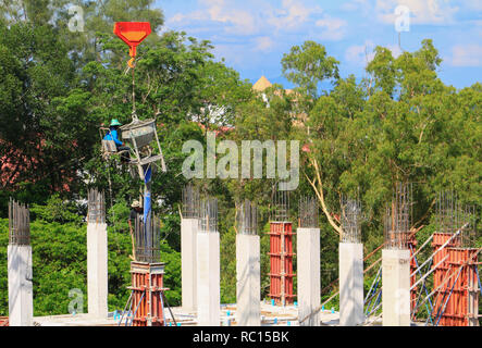 crane lifting concrete mixer container and worker in construction building commercial  in site workplace Stock Photo