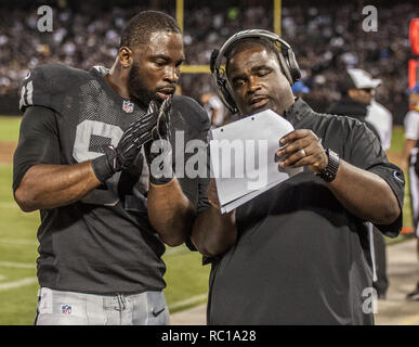 Oakland Raiders defensive end Justin Tuck (91), middle linebacker Miles  Burris (56) and safety Charles Woodson (24) surround Kansas City Chiefs  tight end Travis Kelce (87) as he picks up a first