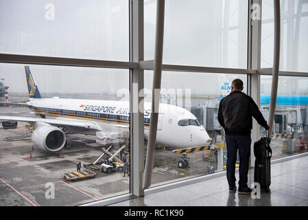 A passenger looks at a Singapore Airlines plane in the waiting area at Hong Kong International Airport.boarding gate. Stock Photo