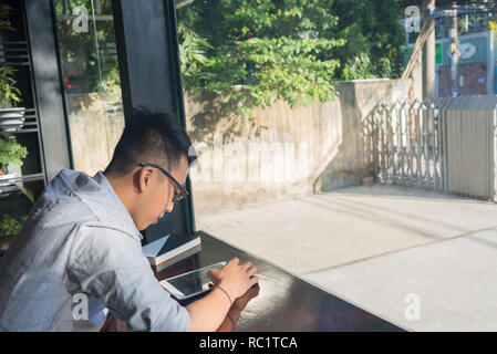 Asian student using tablet to read online newspaper Stock Photo