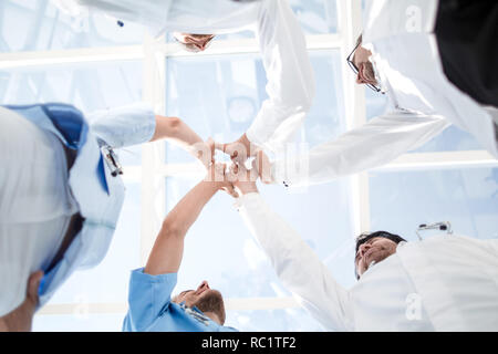 Doctors and nurses in a medical team stacking hands Stock Photo