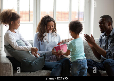 Happy black mom receiving gift box with present from son Stock Photo