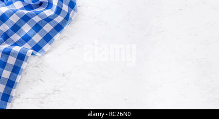 Top of view blue checkered tablecloth on white marble table. Stock Photo