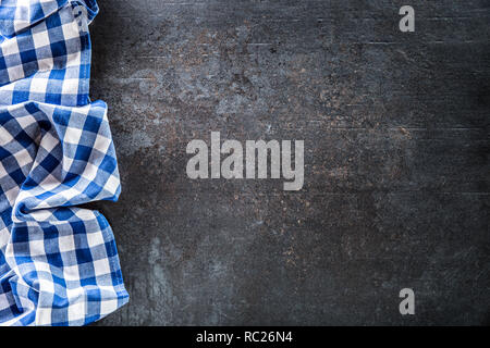Top of view blue checkered tablecloth on dark concrete table. Stock Photo