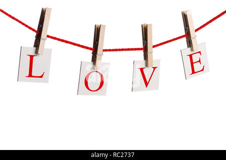 Clothes pegs and word LOVE on papers on rope isolated on white background Valentines day concept Stock Photo