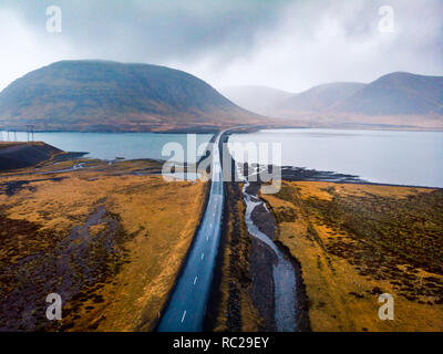 Scenic road in Iceland surrounded by water aerial view Stock Photo