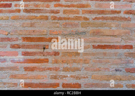 Red Brick wall. Mediterranean style. Aged wall. Concrete and  yellowish bricks. Stock Photo