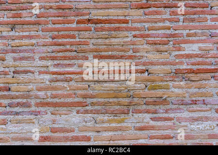 Red Brick wall. Mediterranean style. Aged wall. Concrete and  yellowish bricks. Stock Photo