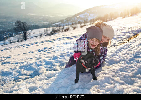 friends in the snow are fooling around with the dog Stock Photo