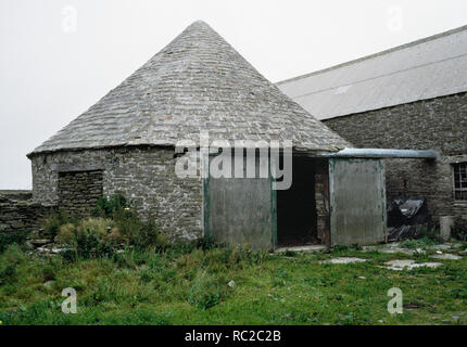 Holland Farm Horse engine house or horse mill tramp, Papa Westray, Orkney. The geared mechanism drove a threshing machine in the adjacent building. Stock Photo