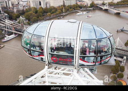 London, United Kingdom - October 31, 2017: Tourists are in the cabin of London Eye. Giant Ferris wheel mounted on the South Bank of River Thames Stock Photo