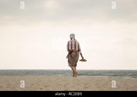 YANTARNY, KALININGRAD REGION, RUSSIA - JULY 20, 2018: Woman walks alone at  coastline of Baltic sea in Kaliningrad region, Russia. Stock Photo
