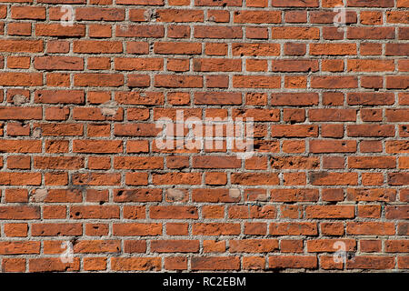 Ancient red brick wall with bullet holes. Stock Photo
